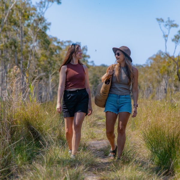 a woman standing next to a tree