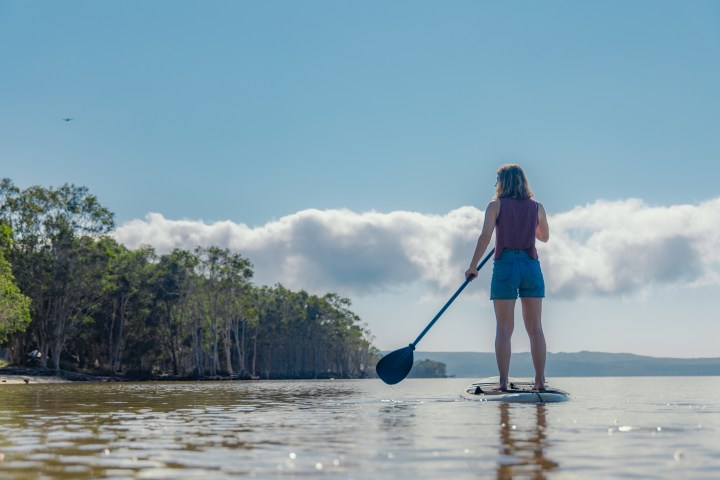 a person standing next to a body of water